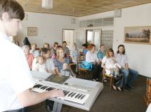 Klavírista doprovázející zpívající děti