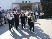 Mužáci přicházející na sólo v čele s hráčem na harmoniku